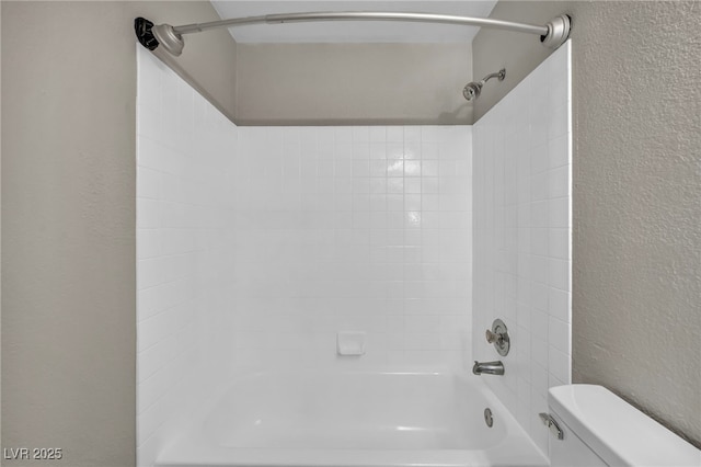 bathroom featuring washtub / shower combination and toilet