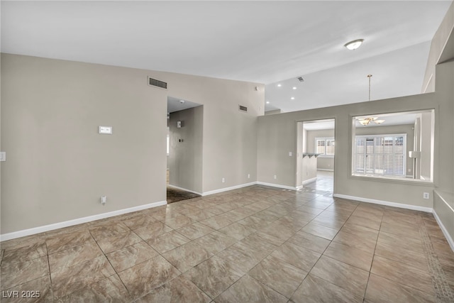 spare room featuring vaulted ceiling and a chandelier