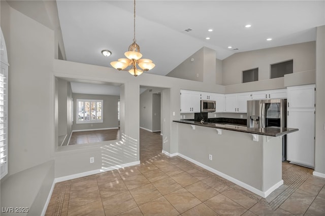 kitchen featuring a breakfast bar area, stainless steel appliances, hanging light fixtures, kitchen peninsula, and white cabinetry