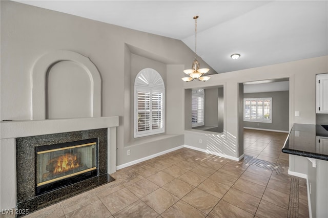 unfurnished living room featuring a high end fireplace, lofted ceiling, light tile patterned floors, and a notable chandelier