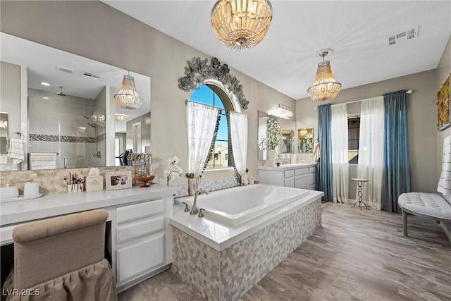 bathroom with separate shower and tub, vanity, and a chandelier