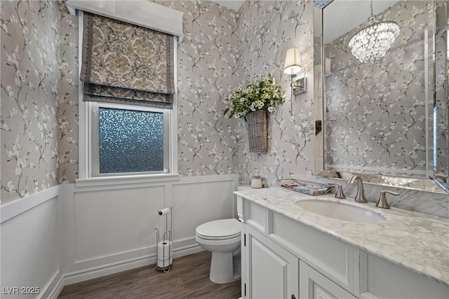 bathroom featuring vanity, toilet, a chandelier, and wood-type flooring