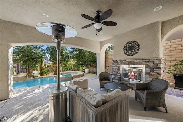 view of patio / terrace with a fenced in pool and an outdoor stone fireplace