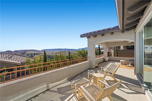 view of patio featuring a balcony and a mountain view