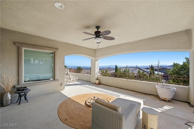 view of patio with ceiling fan and a mountain view