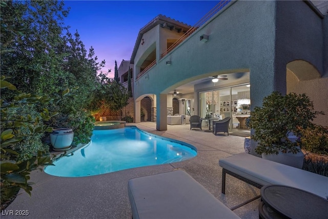 pool at dusk with a patio area and an in ground hot tub