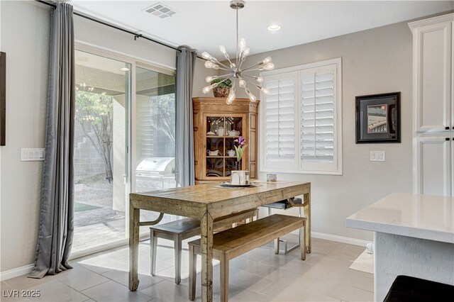 dining room with a notable chandelier and light tile patterned flooring