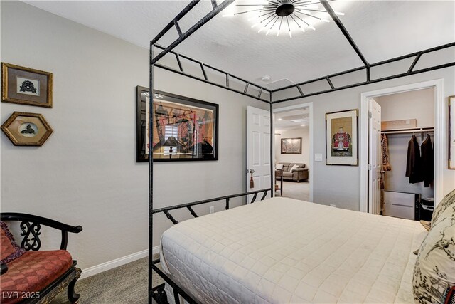 carpeted bedroom featuring a walk in closet, a textured ceiling, and a closet