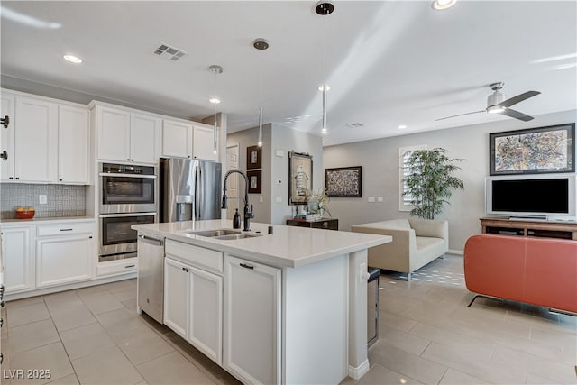 kitchen with sink, a center island with sink, white cabinets, and appliances with stainless steel finishes