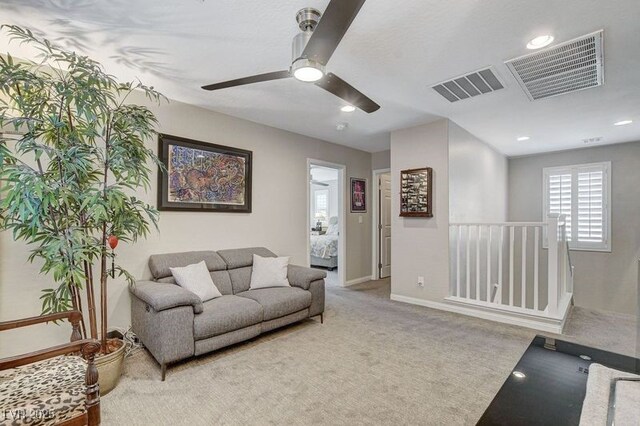 carpeted living room featuring ceiling fan