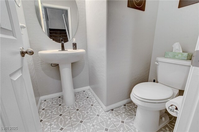 bathroom with toilet and tile patterned flooring