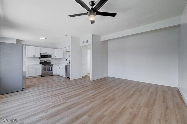 unfurnished living room featuring sink, ceiling fan, and light hardwood / wood-style flooring