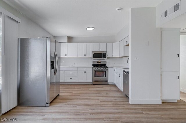 kitchen featuring white cabinets, appliances with stainless steel finishes, light hardwood / wood-style flooring, and sink