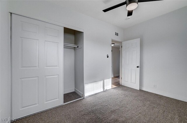 unfurnished bedroom with a closet, ceiling fan, and dark carpet