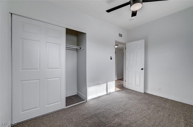 unfurnished bedroom featuring ceiling fan, a closet, and dark colored carpet