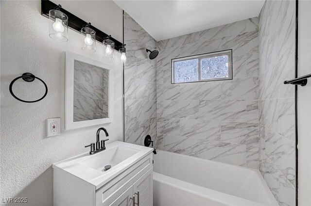 bathroom with tiled shower / bath and vanity