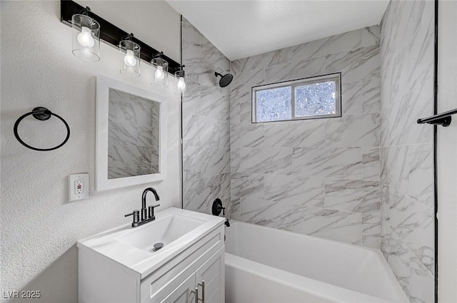 bathroom featuring tiled shower / bath and vanity