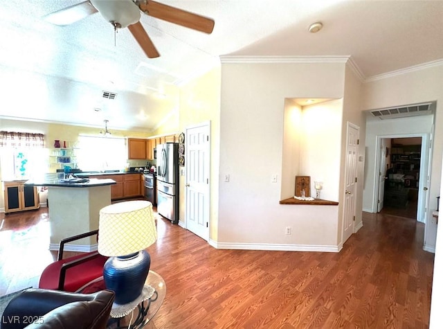 kitchen with kitchen peninsula, hardwood / wood-style flooring, hanging light fixtures, stainless steel fridge with ice dispenser, and a textured ceiling