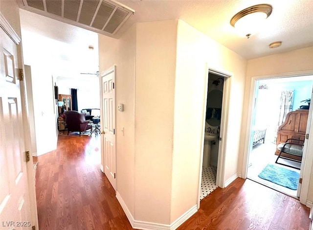 corridor with dark hardwood / wood-style floors and a textured ceiling