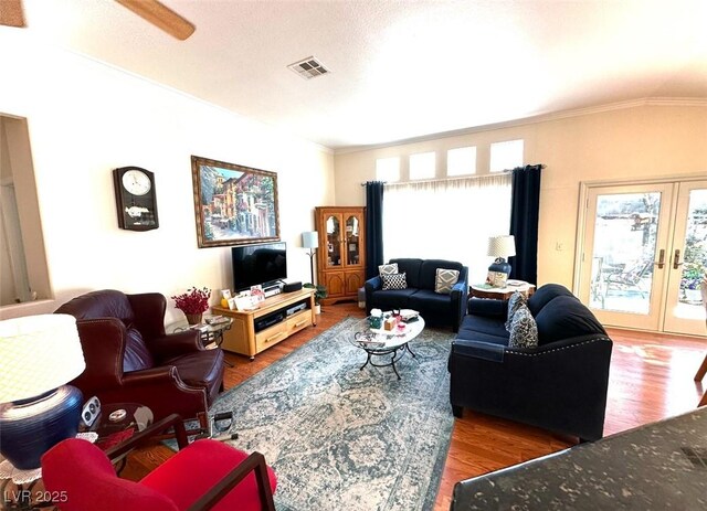 living room with hardwood / wood-style floors, ceiling fan, french doors, a textured ceiling, and crown molding