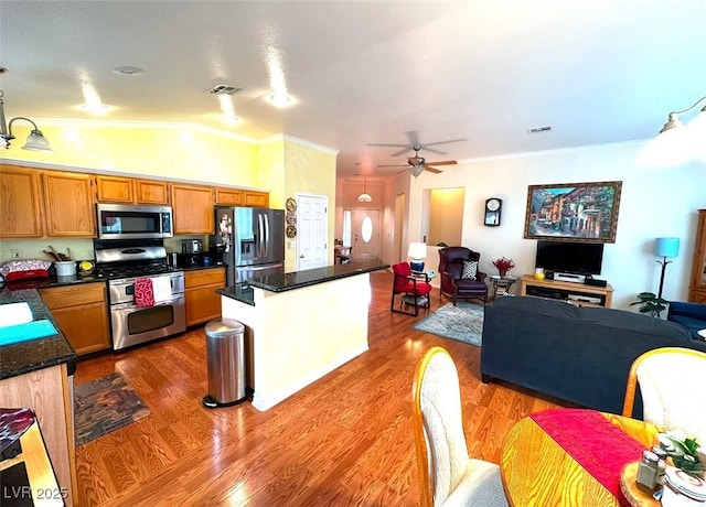 kitchen with vaulted ceiling, ceiling fan, light hardwood / wood-style floors, stainless steel appliances, and crown molding