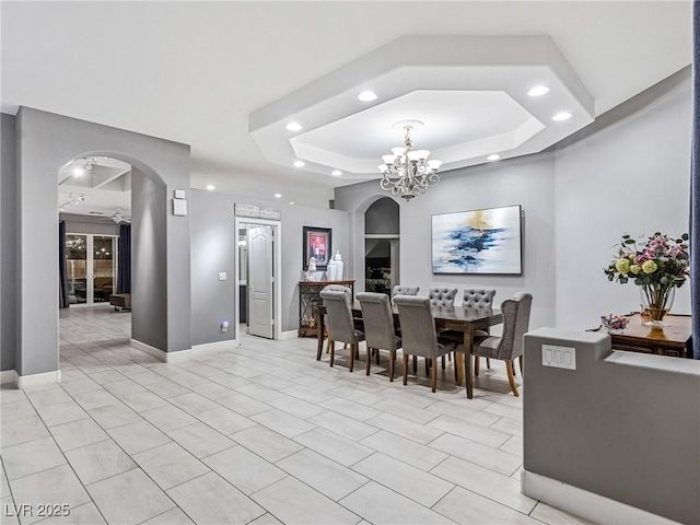 dining room featuring a raised ceiling and an inviting chandelier