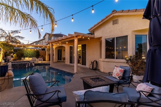 pool at dusk featuring a fire pit and a patio area