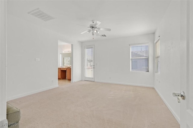 carpeted spare room with ceiling fan and a healthy amount of sunlight