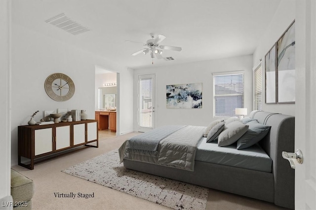 bedroom with ensuite bath, ceiling fan, light carpet, and multiple windows