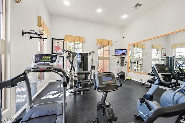 exercise room featuring a towering ceiling