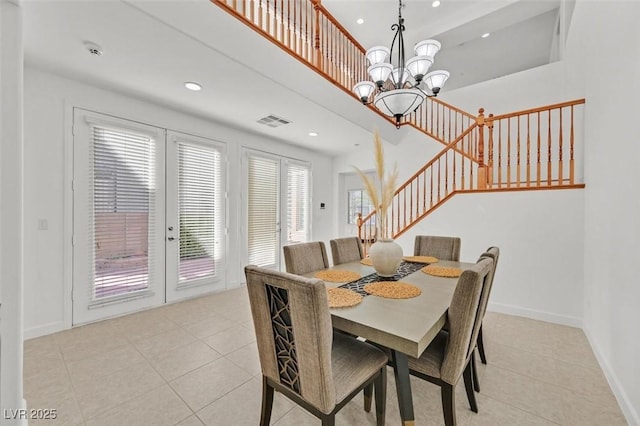 dining space with a notable chandelier, french doors, and light tile patterned flooring