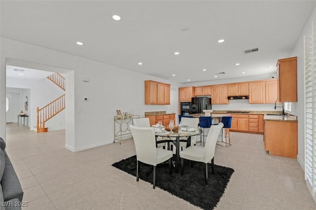 dining space with light tile patterned floors and sink