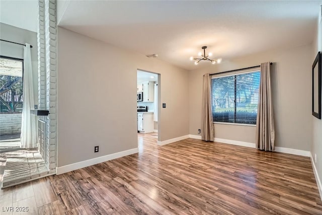 spare room with a chandelier and hardwood / wood-style flooring