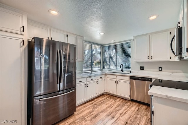 kitchen featuring appliances with stainless steel finishes, white cabinets, and sink