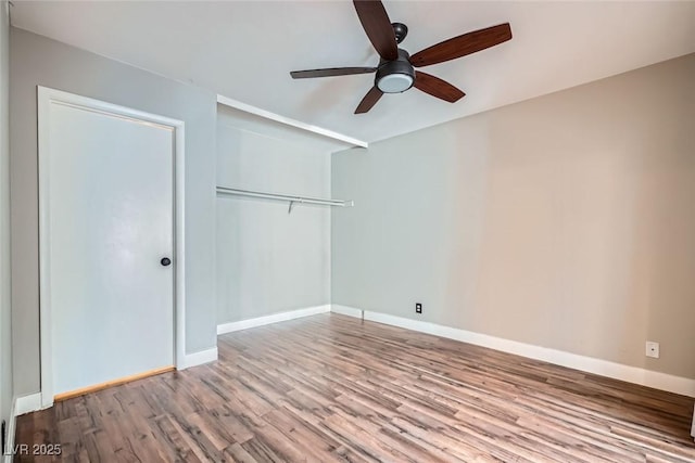 unfurnished bedroom with ceiling fan, a closet, and wood-type flooring