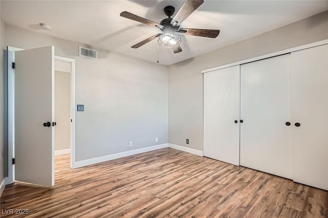 unfurnished bedroom featuring ceiling fan, light hardwood / wood-style flooring, and a closet