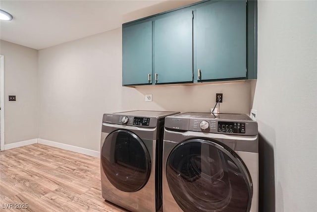 clothes washing area with light wood-type flooring, cabinets, and washing machine and clothes dryer