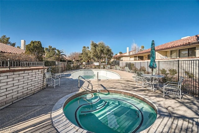 view of pool with a patio and a hot tub