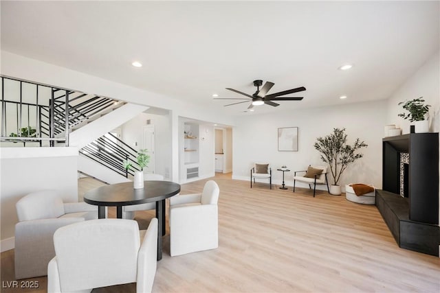 living room with ceiling fan and light hardwood / wood-style floors