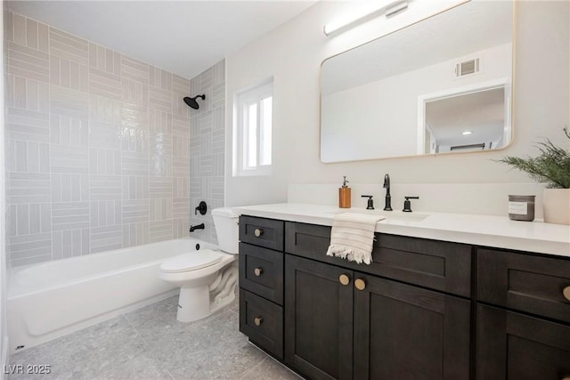 full bathroom with vanity, tiled shower / bath combo, and toilet