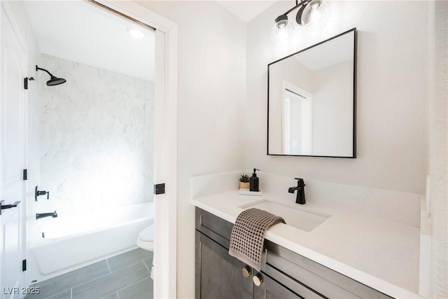 full bathroom featuring toilet, tiled shower / bath, and vanity