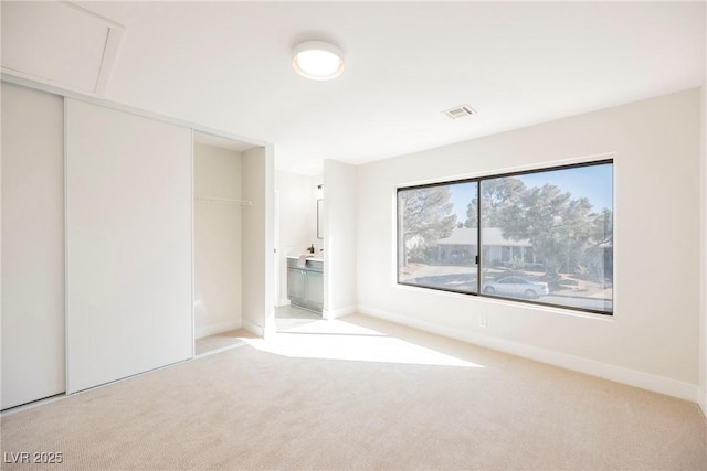 unfurnished bedroom with a closet and light carpet