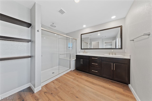 bathroom with a shower with shower door, wood-type flooring, and vanity