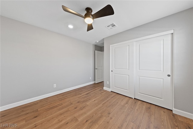 unfurnished bedroom with ceiling fan, light wood-type flooring, and a closet