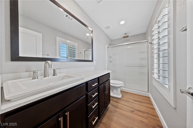 bathroom with walk in shower, toilet, vanity, and hardwood / wood-style flooring