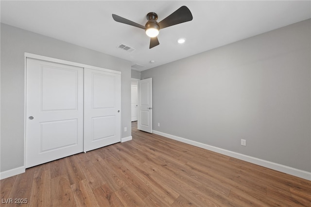 unfurnished bedroom featuring light wood-type flooring, ceiling fan, and a closet