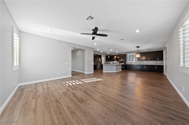 unfurnished living room with ceiling fan and dark hardwood / wood-style floors