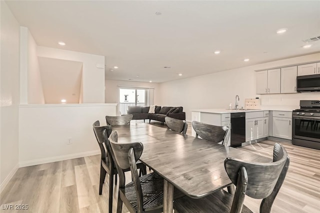 dining space with sink and light hardwood / wood-style floors