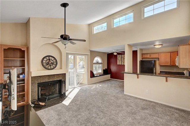 unfurnished living room featuring a high ceiling, french doors, carpet floors, and ceiling fan