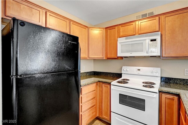 kitchen with white appliances and dark stone counters